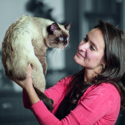 Хозяйка держит кошку на руках