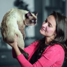 Хозяйка держит кошку на руках